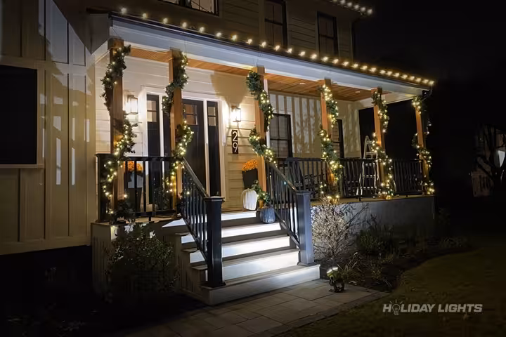 Elegant Christmas garlands decorating porch pillars with warm white LED lighting